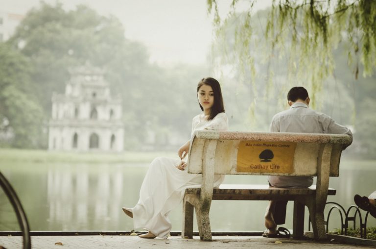 man and woman fighting sitting on a bench