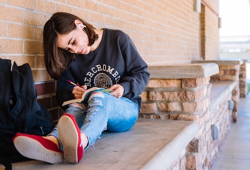 teenage girl writing in her noteboook